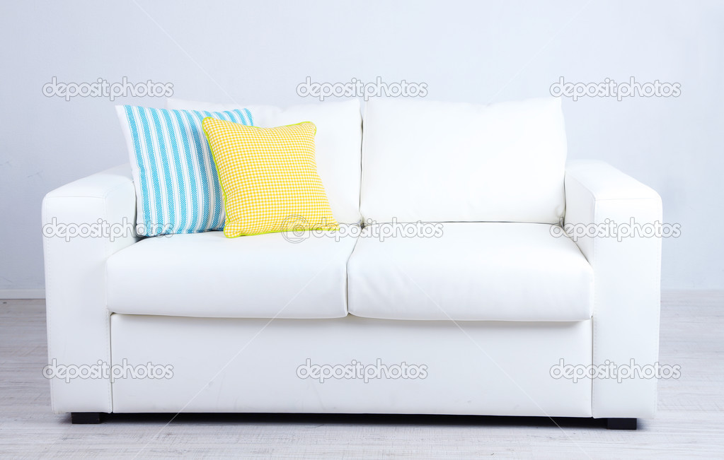 White sofa with colorful pillows in room 
