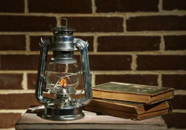 yakıcı gaz lambası ve tuğla duvar zemin üzerine kitaplar