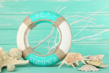 Lifebuoy and sea shells on wooden background