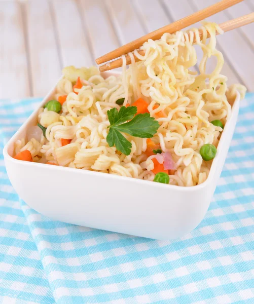 Νόστιμο στιγμιαία noodles με λαχανικά σε μπολ σε κοντινό πλάνο του πίνακα — Φωτογραφία Αρχείου