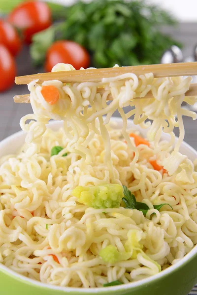 Νόστιμο στιγμιαία noodles με λαχανικά σε μπολ σε κοντινό πλάνο του πίνακα — Φωτογραφία Αρχείου