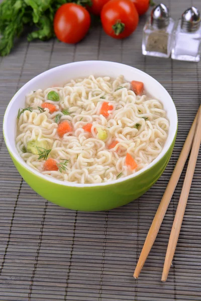 Sabrosos fideos instantáneos con verduras en un tazón en la mesa de cerca —  Fotos de Stock