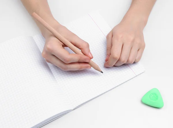 Человеческие руки с карандашом и стереть резину и ноутбук, изолированные на белом — стоковое фото
