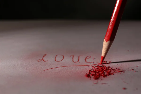 Word Love and breaking pencil on paper, close up — Stock Photo, Image