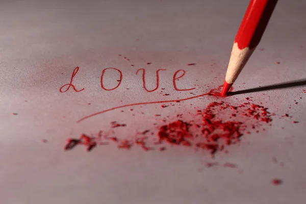 Word Love and breaking pencil on paper, close up — Stock Photo, Image
