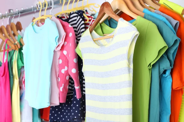 Verschiedene Kleidungsstücke auf Kleiderbügeln aus nächster Nähe — Stockfoto
