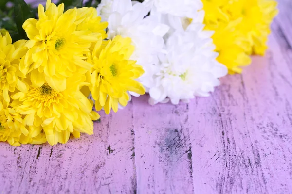 Schöne Chrysanthemenblüten auf Holztisch in Großaufnahme — Stockfoto