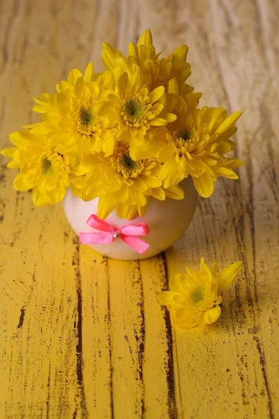 Schöne Chrysanthemenblüten in Vase auf Holztisch in Großaufnahme — Stockfoto