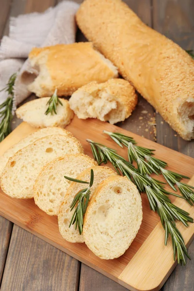 Pan fresco con aceite de oliva y romero sobre mesa de madera —  Fotos de Stock