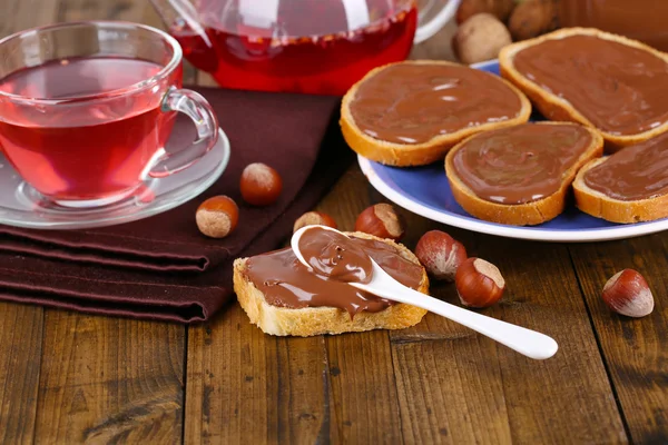 Bröd med söt chokladhasselnöt på tallriken på bordet — Stockfoto