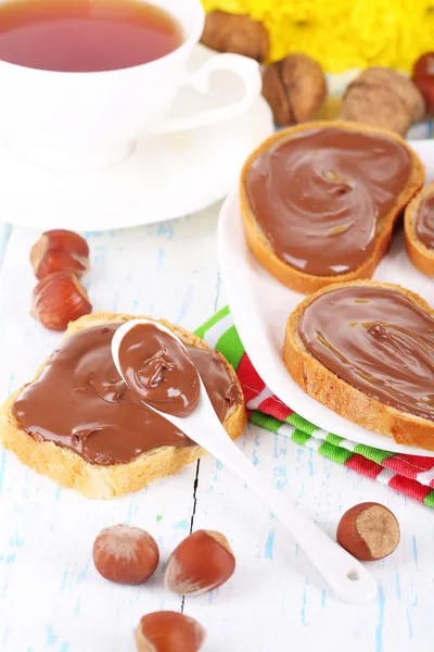 Pan con avellana de chocolate dulce extendido en el plato en la mesa —  Fotos de Stock