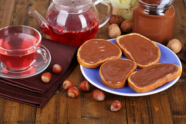 Pan con avellana de chocolate dulce extendido en el plato en la mesa —  Fotos de Stock