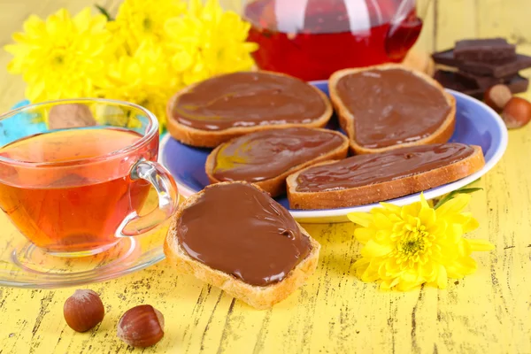 Pan con avellana de chocolate dulce extendido en el plato en la mesa —  Fotos de Stock