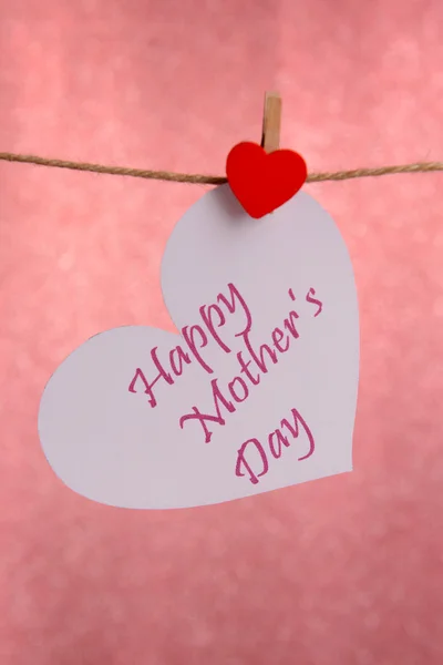 Feliz Día de las Madres mensaje escrito en el corazón de papel sobre fondo rosa —  Fotos de Stock