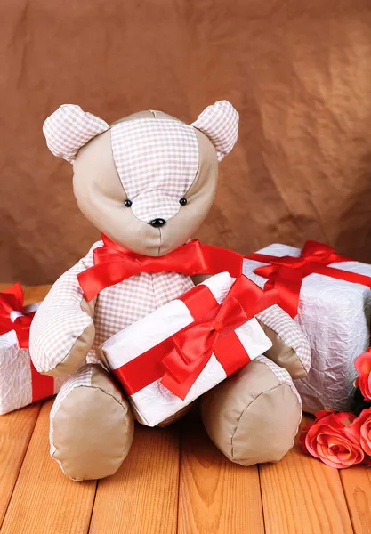 Brinquedo de urso na mesa no fundo marrom — Fotografia de Stock