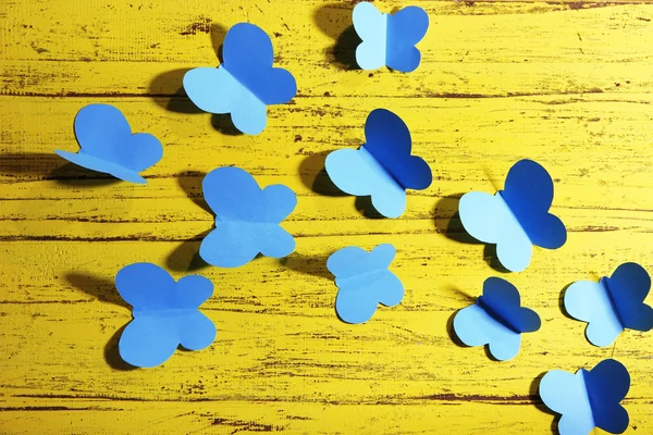 Paper cut out butterflies, on wooden background — Stock Photo, Image