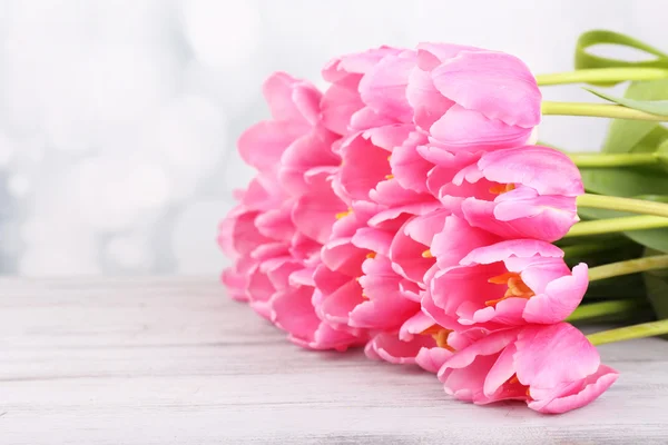 Beautiful pink tulips on wooden table — Stock Photo, Image