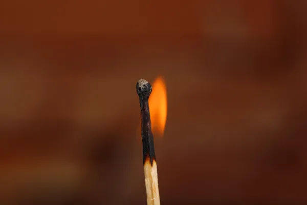 Burning match on color background — Stock Photo, Image