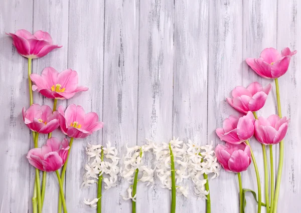 Beautiful flowers on color wooden background — Stock Photo, Image