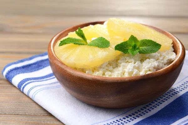 Tigela de queijo cottage saboroso com abacaxi na mesa de madeira — Fotografia de Stock