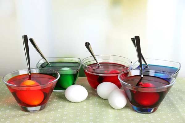 Yumurta ile sıvı renk cam parlak zemin üzerine masada — Stok fotoğraf