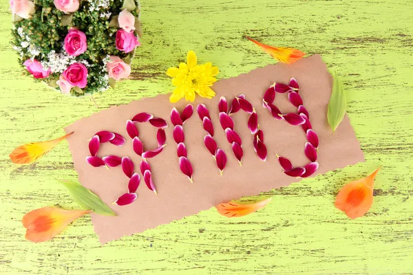 Romantic spring letters made of pink petals, on wooden background — Stock Photo, Image