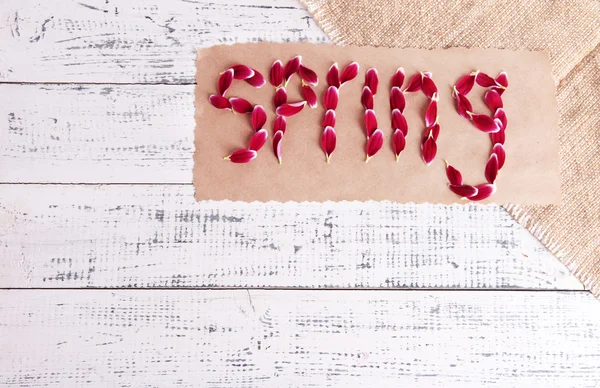 Romantische Frühlingsbuchstaben aus rosa Blütenblättern, auf Holzgrund — Stockfoto