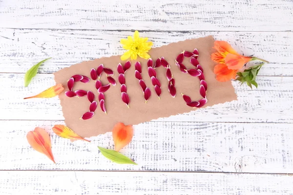 Romantyczna wiosna litery wykonane z płatki różowy, na tle drewniane — Zdjęcie stockowe