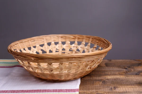 Порожній плетений кошик на дерев'яному столі, на темному тлі — стокове фото