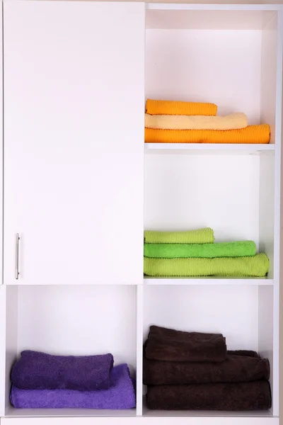 Estantes blancos con toallas de colores de cerca —  Fotos de Stock