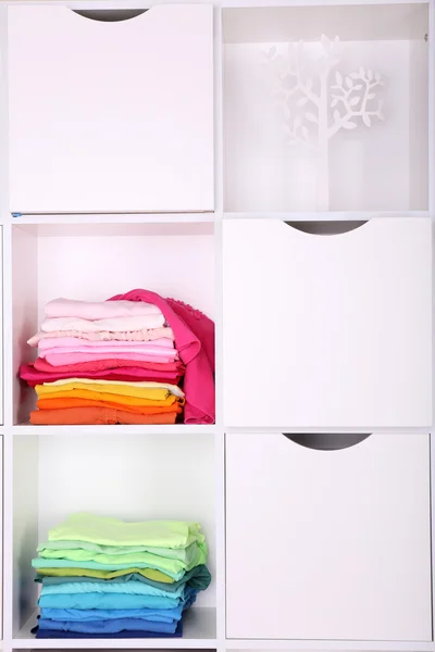 White shelves with colored clothing close up — Stock Photo, Image