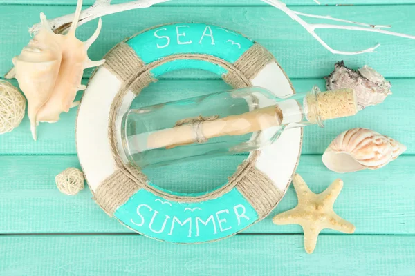 Lifebuoy and sea shells on wooden background — Stockfoto