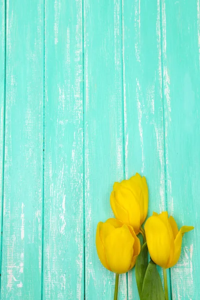 Hermosos tulipanes sobre fondo de madera color — Foto de Stock