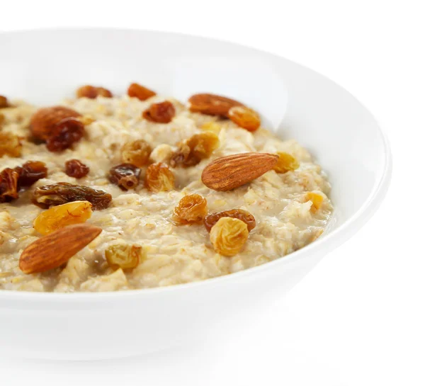 Tasty oatmeal with raisins isolated on white — Stock Photo, Image