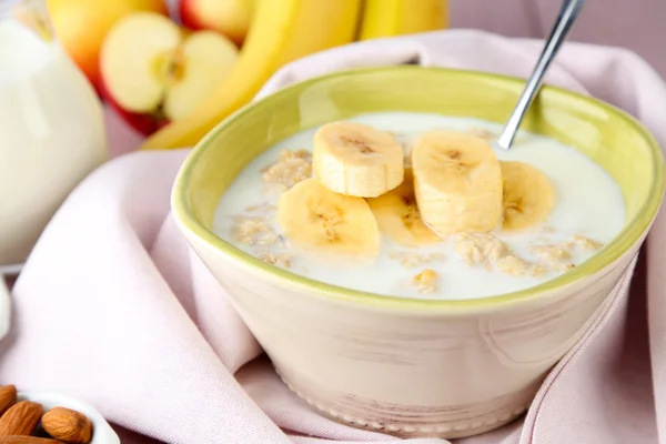 Farinha de aveia saborosa com bananas e leite na mesa close-up — Fotografia de Stock