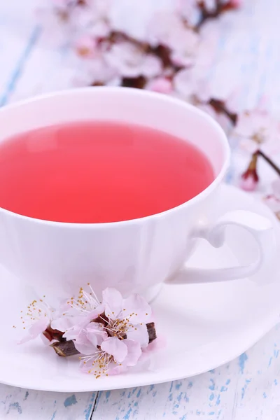 Fragrant tea with flowering branches on wooden table close-up — Stock Photo, Image