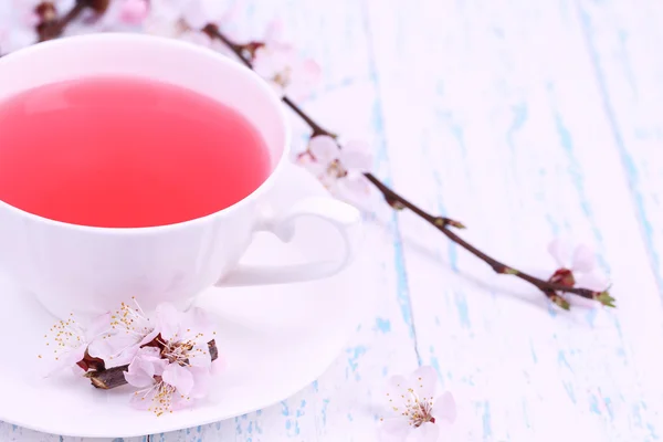 Fragrant tea with flowering branches on wooden table close-up — Stock Photo, Image