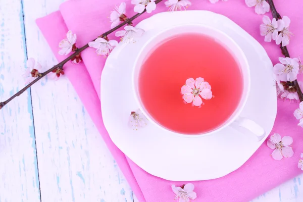 Fragrant tea with flowering branches on wooden table close-up — Stock Photo, Image