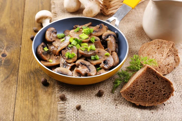 Heerlijke gebakken champignons in pan op tafel close-up — Stockfoto