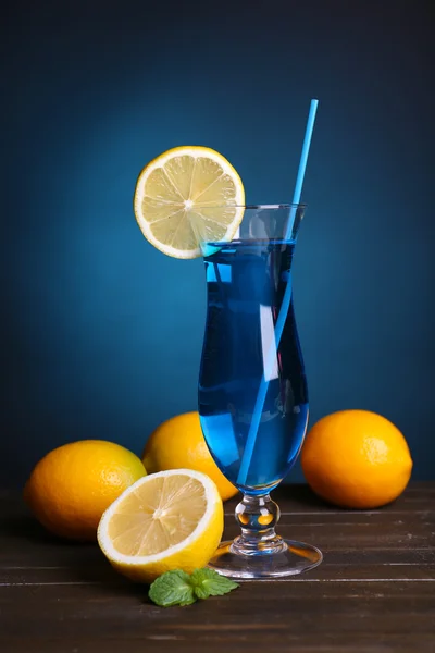 Cocktailglas auf Tisch auf dunkelblauem Hintergrund — Stockfoto