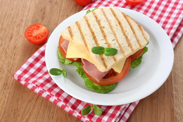Tasty sandwich with ham on wooden table — Stock Photo, Image
