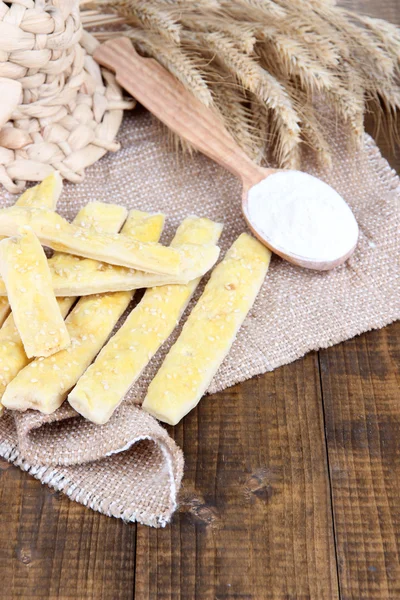 Bread sticks on sackcloth on wooden background — Stock Photo, Image