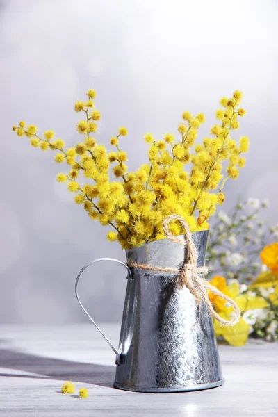 Větvičky mimózy květin ve váze na dřevěný stůl — Stock fotografie
