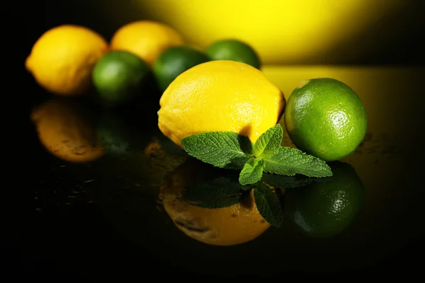 Лимоны и лаймы на темном фоне — стоковое фото