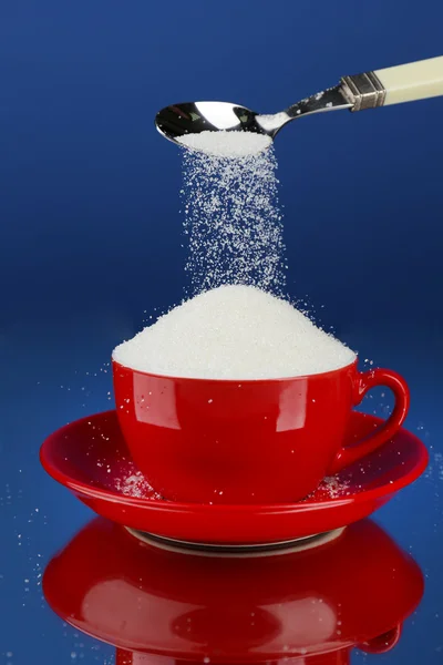 Zucker im Becher auf blauem Hintergrund — Stockfoto