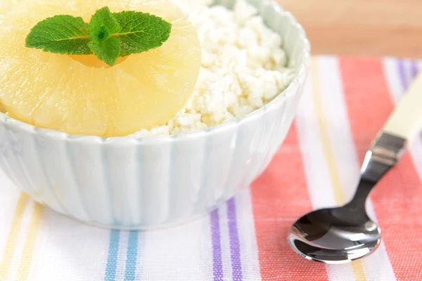 Bowl of tasty cottage cheese with pineapple on wooden table — Stock Photo, Image
