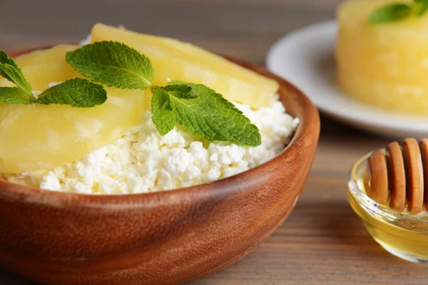 Kom lekker cottage kaas met ananas op houten tafel — Stockfoto