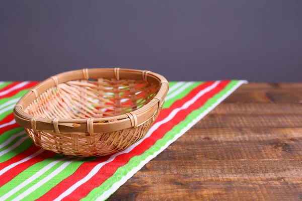 Cesta de mimbre vacía sobre mesa de madera, sobre fondo oscuro —  Fotos de Stock