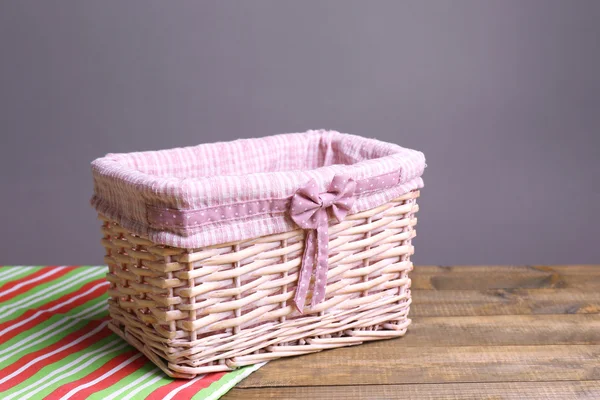 Empty wicker basket on wooden table, on dark background — Stock Photo, Image