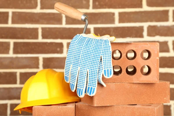 Nieuwe bakstenen en gebouw tools op bakstenen muur achtergrond — Stockfoto